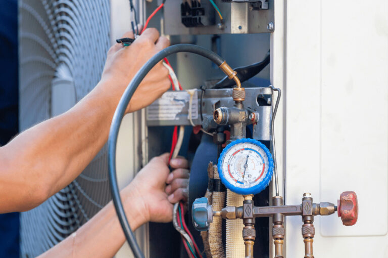 AN HVAC technician performs maintenance on a unit