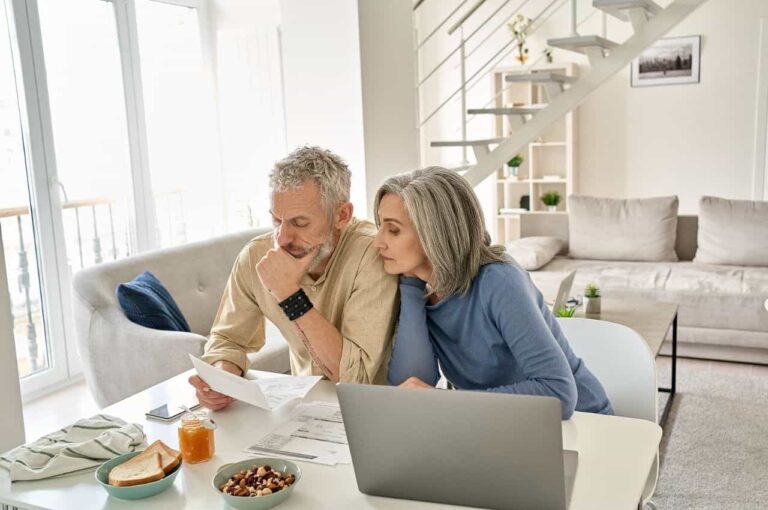 A couples sits at a table and looks over an AC warranty document