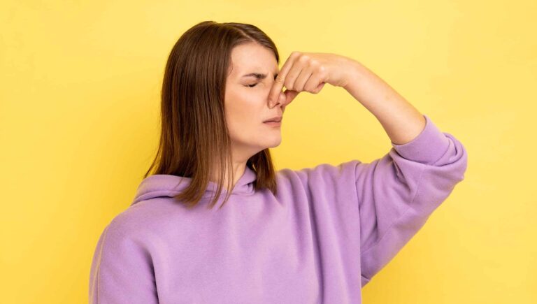 A woman smelling something bad