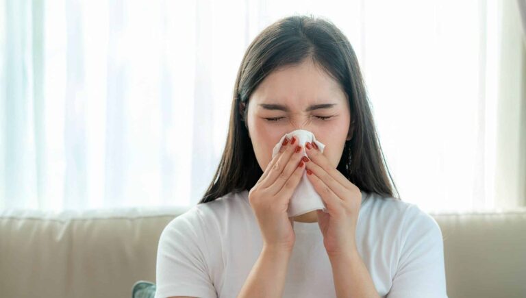 A woman blowing her nose