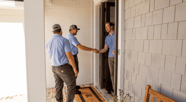 HVAC technicians meeting a customer