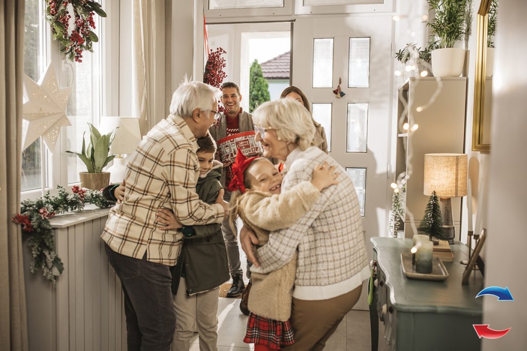 Grandparents welcoming grandchildren and parents for Christmas at home.