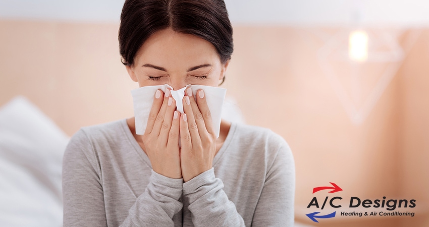 Young woman having allergies with the A/C designs logo at the bottom of the graphic