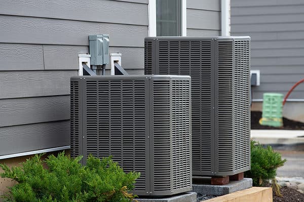 Two air conditioner units outside of a house