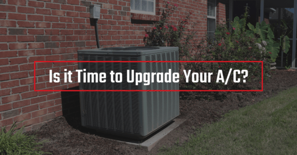An outdoor A/C unit outside of a brick home. Text reads "Is It Time to Upgrade Your A/C?