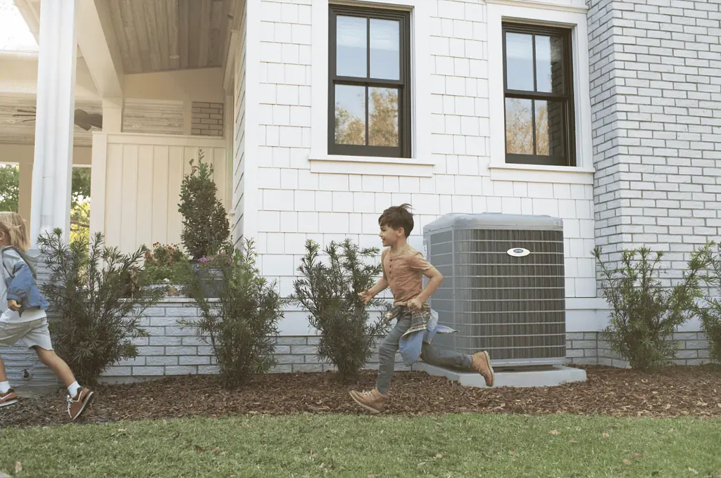 Kids running in front of a house