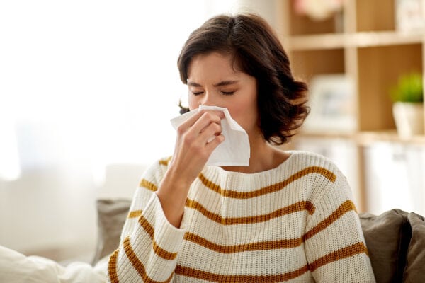 woman sneezing into tissue3