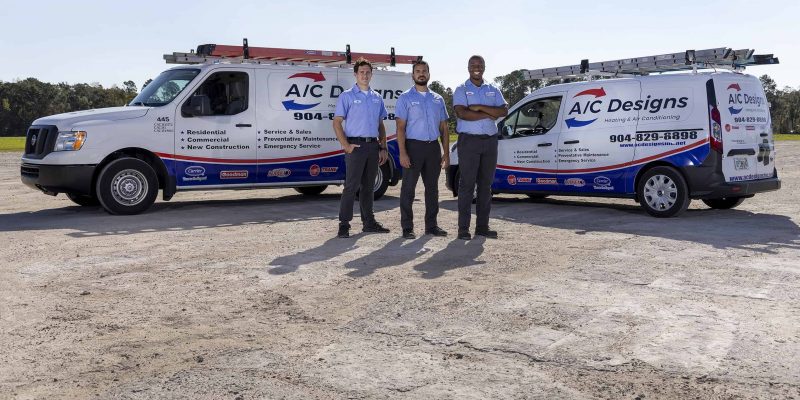ac designs team in front of vehicles