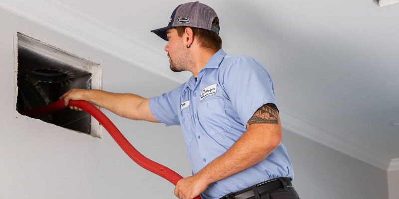 AC Designs technician performing air duct cleaning services