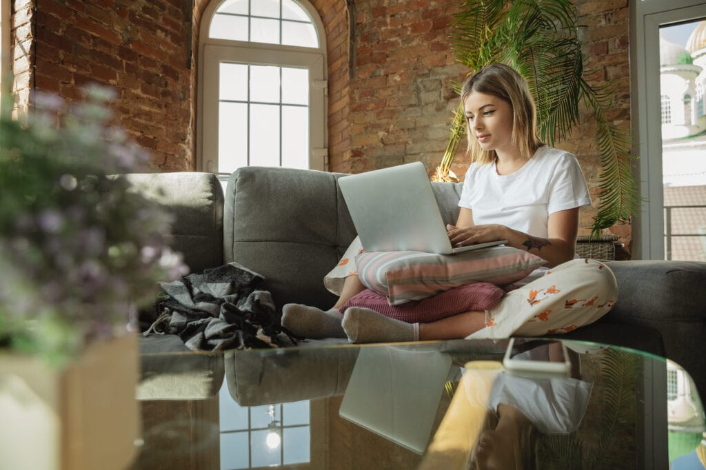 young girl on laptop sitting on couch